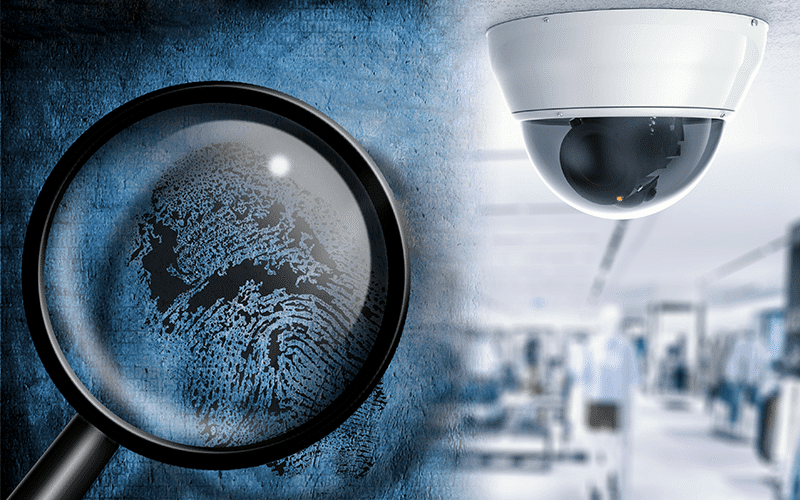 Blue-tone image of a magnifying glass focused on a fingerprint next to credit cards to represent organized retail crime